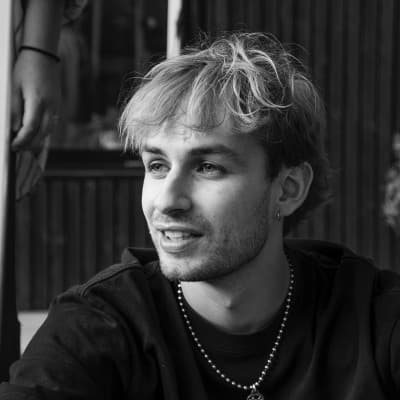 Lucas Bellier, smiling, in black and white